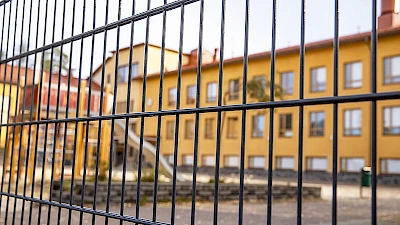 Koulun piha on aidattu mustalla elementtiaidalla.