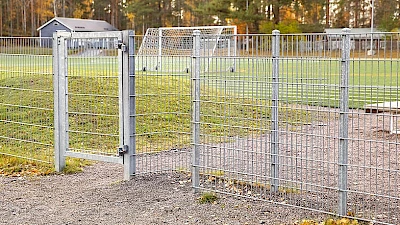 Urheilukentälle on tehty kulkuaukko, josta ei pallot karkaa ja vieressä on käyntiportti, josta pääsee vaikka lastenvaunuilla. Urheilukenttä on aidattu kuumasinkityllä elementtiaidalla ja käyntiportti on tehty samasta materiaalista.
