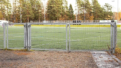 Urheilukenttä on aidattu kuumasinkityllä elementtiaidalla ja urheilukentälle pääsee ajoneuvoilla kaksilehtisen huoltoportin kautta ja jalankulkijat yksilehtisen käyntiportin kautta.
