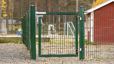 Päiväkodin pihaporttina on vihreä yksilehtinen, saranoitu käyntiportti.
