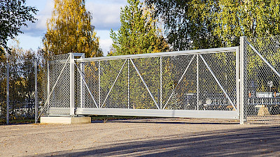 Aluminium side sliding gate attached with chain link fencing.