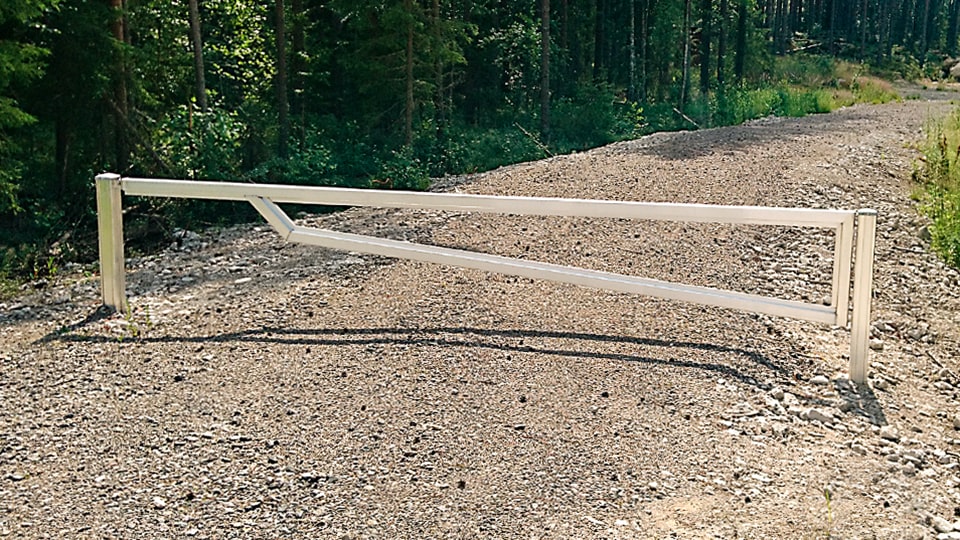 Alumiininen kääntöpuomi hiekkatiellä.