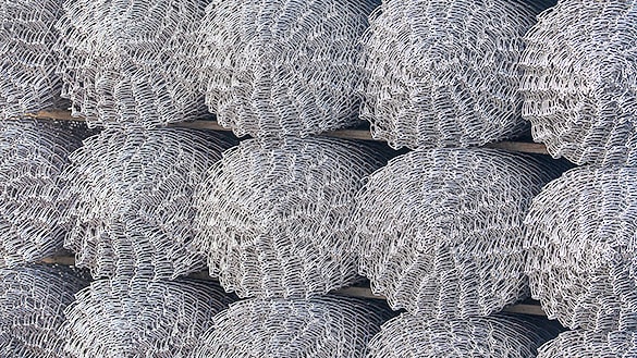 Several rolls of chain link mesh stacked for storage
