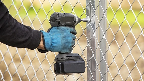 Fastening the chain link fence to aluminium fence post by a drilling machine and a fastening plate.